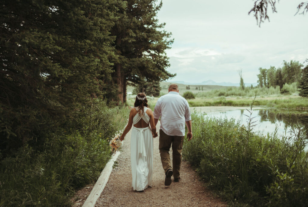 Bride and groom walking at Schwabacher Landing in Grand Teton