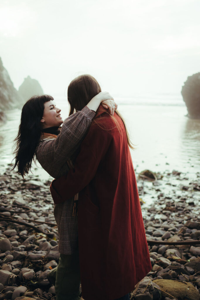 Couple hugging at Hug Point Beach during adventure photoshoot