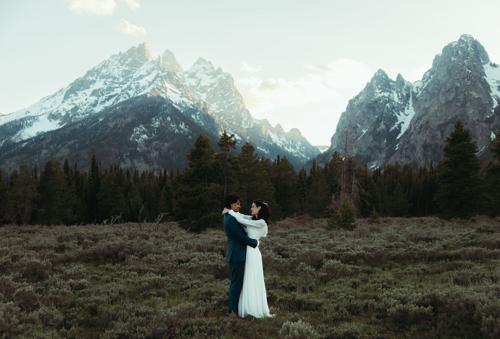 bride and groom embracing at their grand teton wedding at the wedding tree